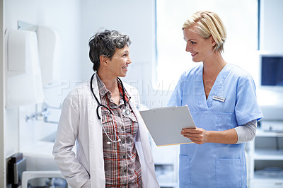 Buy stock photo Shot of two doctors having a discussion in a hospital