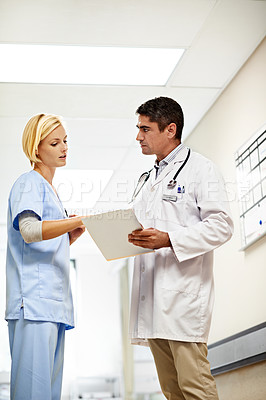 Buy stock photo Shot of two doctors having a discussion in a hospital corridor