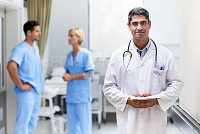 Buy stock photo Portrait of a confident doctor with medical staff in the background