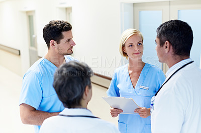 Buy stock photo Shot of a team of doctors having a discussion in a hospital