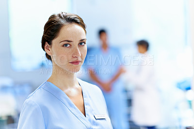 Buy stock photo Portrait of a young doctor with medical staff in the background