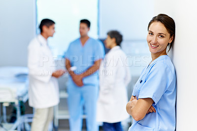 Buy stock photo Portrait of a confident doctor with medical staff in the background