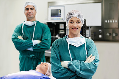 Buy stock photo Portrait of a confident doctor in the operating room with her surgical team in the background