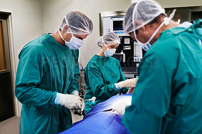 Buy stock photo Shot of a team of surgeons performing an operation