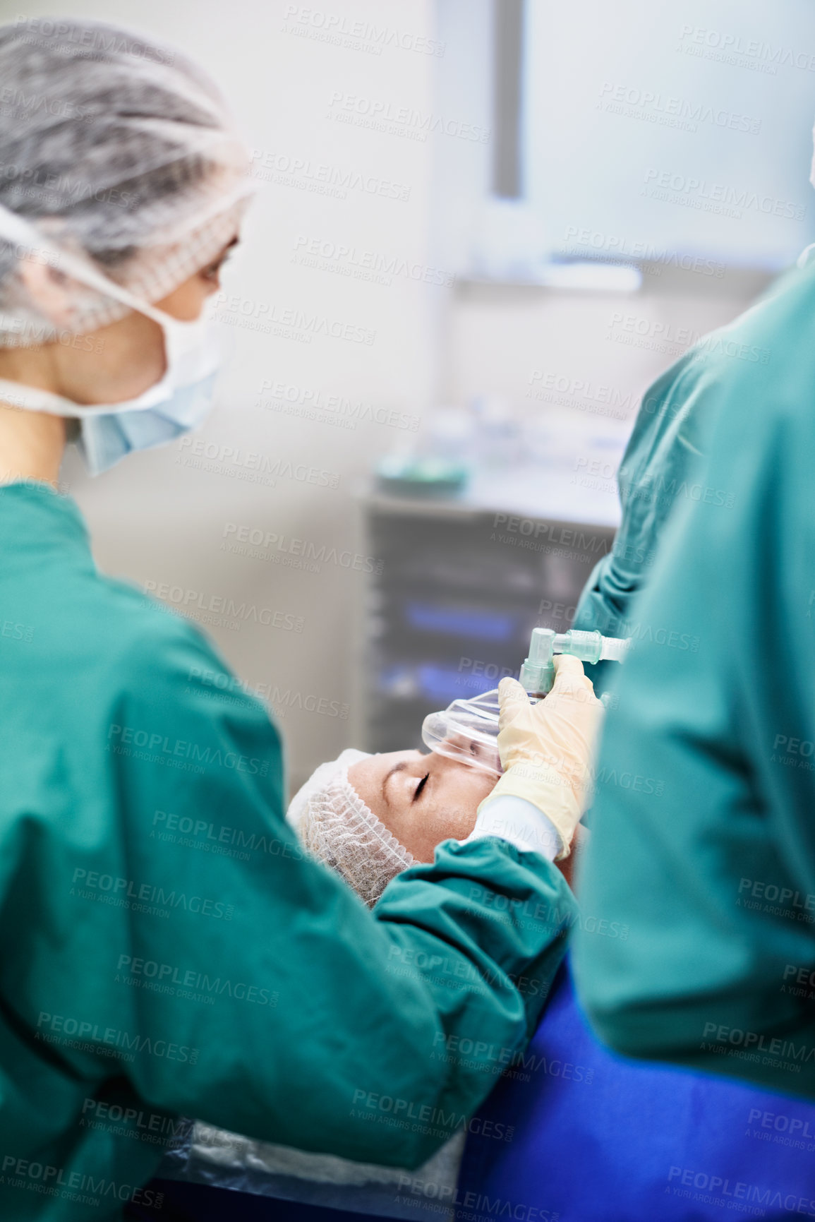 Buy stock photo Shot of a surgeon using a mask on a patient during an operation