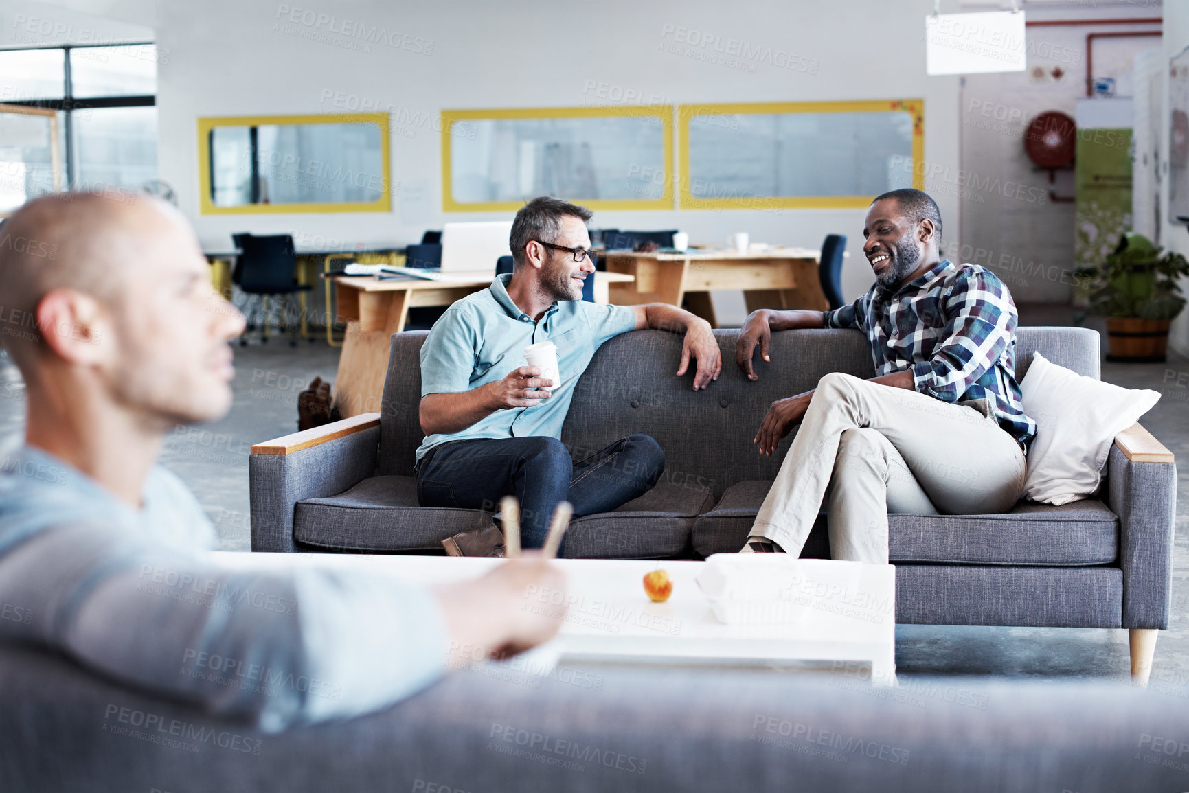 Buy stock photo Smile, business and people in office for break, friendly chat and company gossip for catchup. Happy, team and men in workplace with coffee, discussion and employees socialising on sofa for downtime