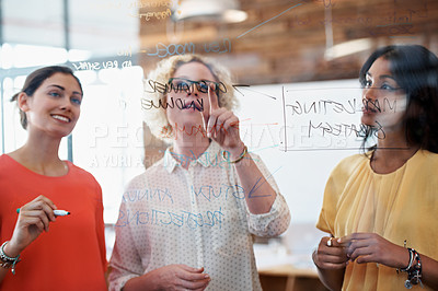 Buy stock photo Cropped shot of three businesswoman working on a glass wall