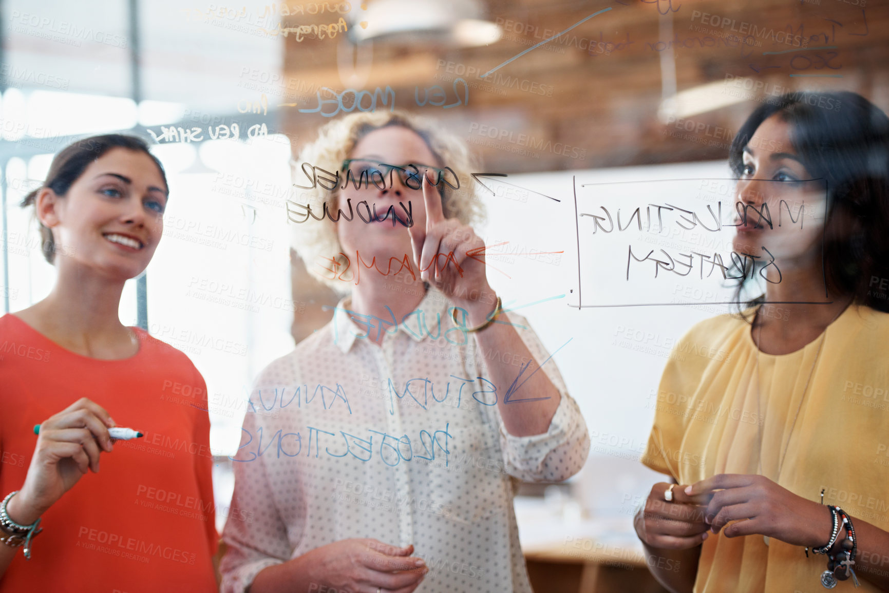Buy stock photo Cropped shot of three businesswoman working on a glass wall