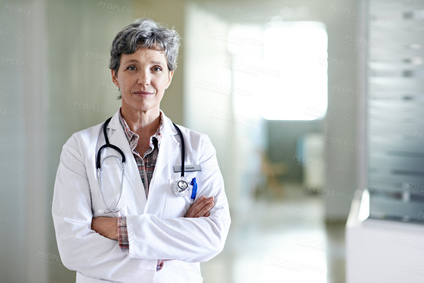 Buy stock photo Portrait of a mature female doctor standing in a hospital corridor