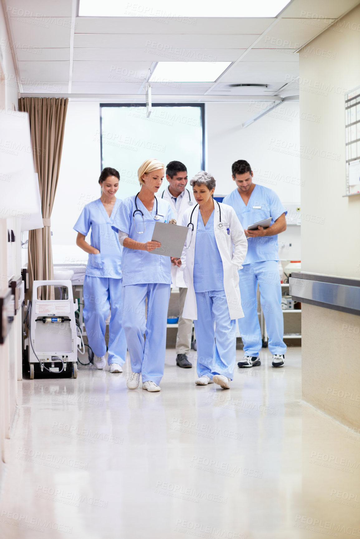 Buy stock photo Meeting, hospital and doctors walking in corridor for discussion, patient review and consulting. Healthcare, clipboard and people in hallway for talking, surgery report and advice for medical service