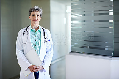 Buy stock photo Portrait of a mature female doctor standing in a hospital corridor
