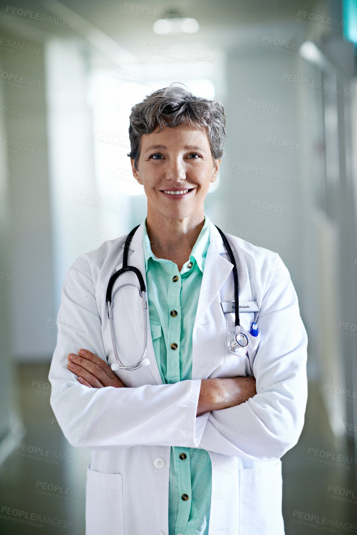 Buy stock photo Doctor, portrait or happy woman with confidence in hospital hallway for medical service or healthcare. Mature, female person or health worker with smile or arms crossed for medicare advice in clinic