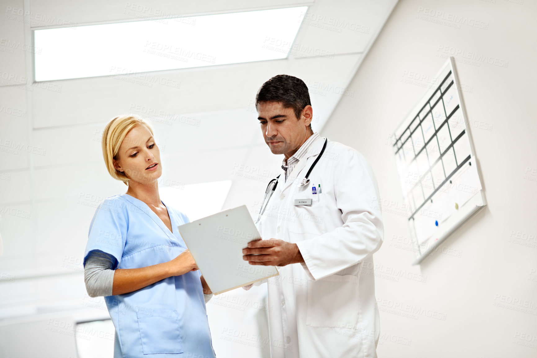 Buy stock photo Clinic, team and talk with medical checklist for case discussion, test results or doctor advice. Nurse, people and clipboard on low angle for health records, treatment options and care coordination