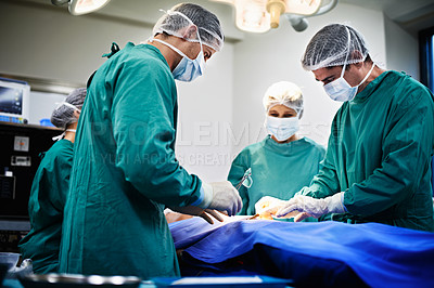 Buy stock photo Shot of surgeons working on a patient in an operating room