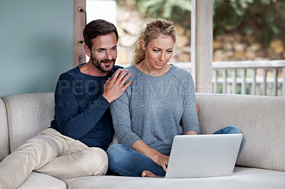 Buy stock photo Cropped shot of a couple using a laptop while relaxing on the sofa
