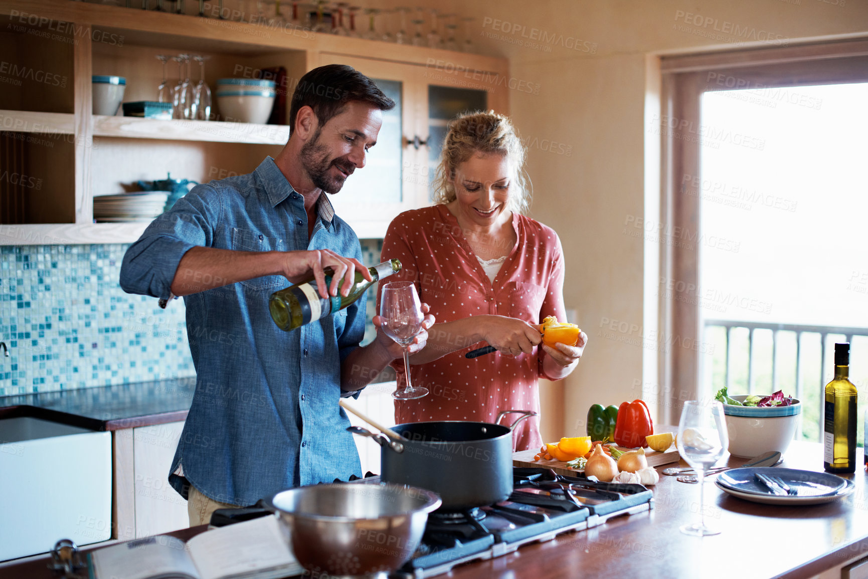 Buy stock photo Shot of a happy couple preparing a meal at home