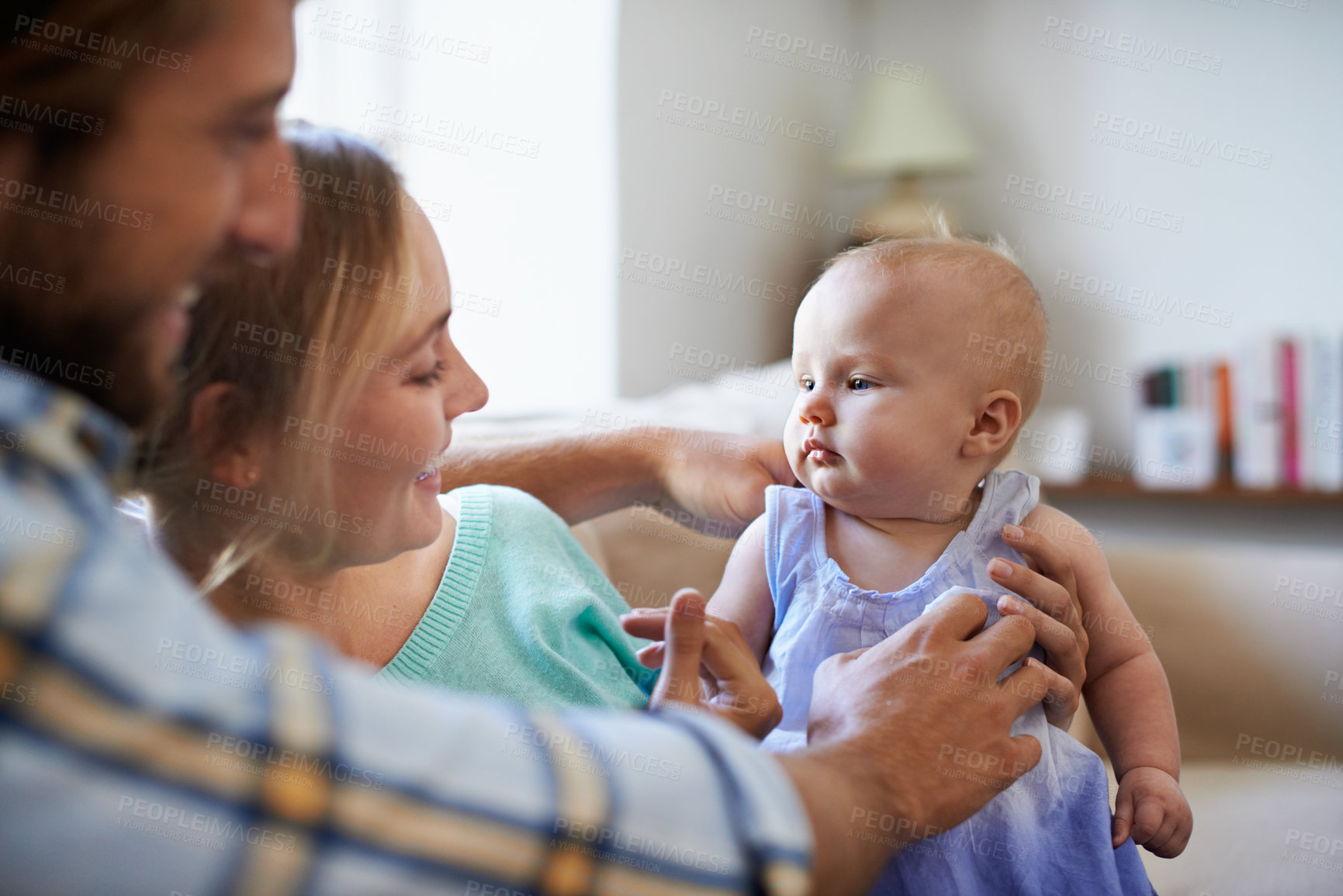 Buy stock photo Happy, parents and baby in living room with love, connection and bonding together on weekend break. People, mother and father nurture infant daughter in family home with support, trust and wellness.