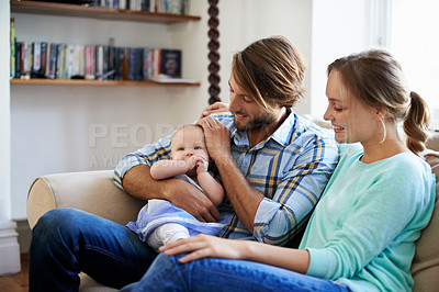 Buy stock photo Shot of a young couple playing with their baby at home