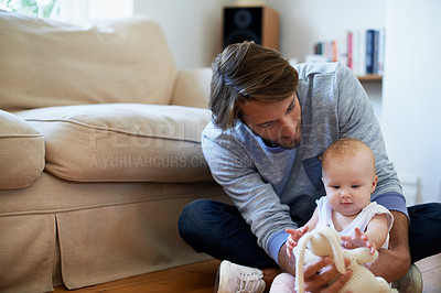 Buy stock photo Shot of a smiling father playing with his baby girl at home
