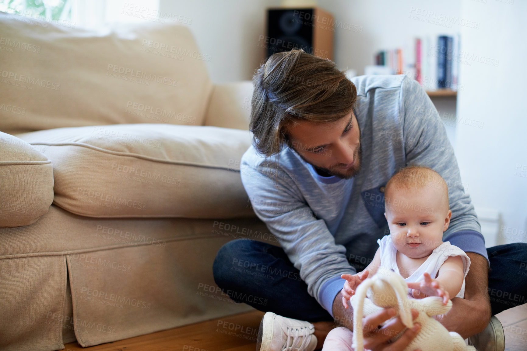 Buy stock photo Shot of a smiling father playing with his baby girl at home