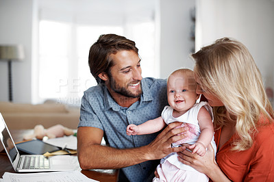 Buy stock photo Shot of a young couple playing with their baby at home