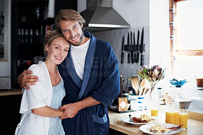 Buy stock photo Portrait of a young couple standing in the kitchen while cooking breakfast