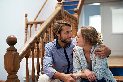 Buy stock photo Shot of an affectionate couple sitting on the staircase at home