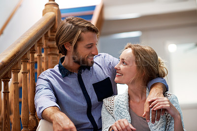 Buy stock photo Shot of an affectionate couple sitting on the staircase at home