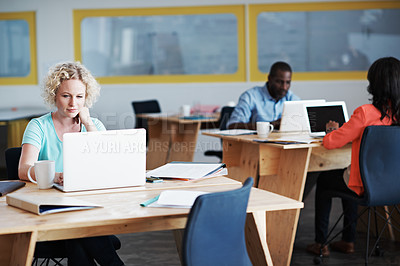 Buy stock photo Cropped shot of a young businesswoman working at her desk with her colleagues in shot