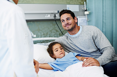 Buy stock photo Shot of a little girl lying in a hospital bed being comforted by her father