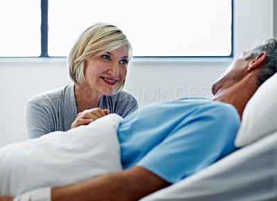 Buy stock photo Shot of a woman comforting her husband lying in a hospital bed