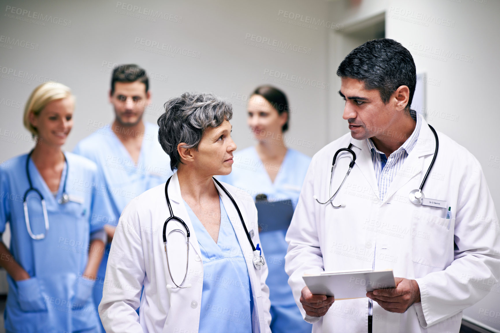 Buy stock photo Doctors, team and walking in hospital at clipboard, medical report and patient chart for diagnosis. People, surgeon or collaboration in workplace with checklist, pathology results or surgery outcome