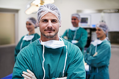 Buy stock photo Portrait of a surgeon standing in an operating room with colleagues in the background
