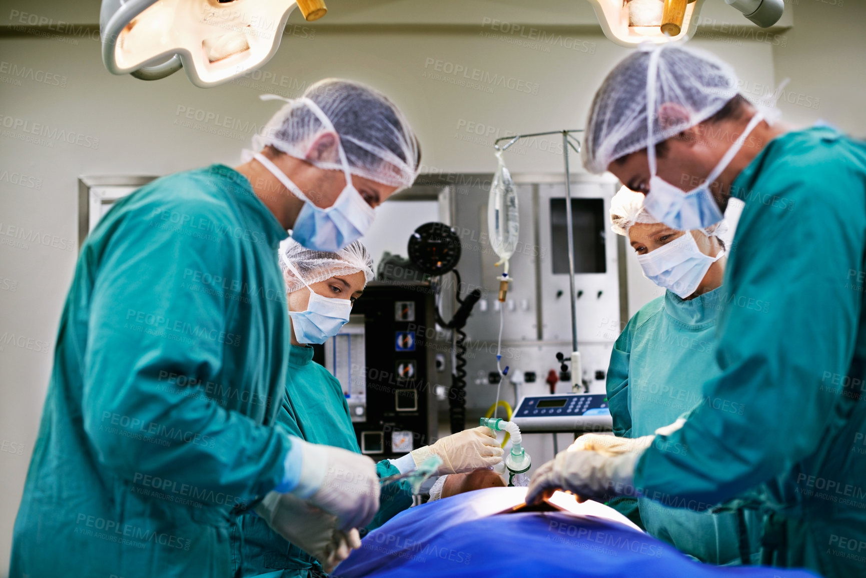 Buy stock photo Shot of a group of surgeons at work in an operating room