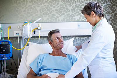 Buy stock photo Shot of a doctor talking to a patient in a hospital ward