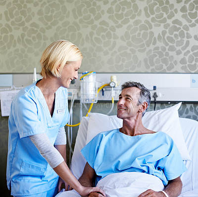 Buy stock photo Shot of a nurse talking to a patient in a hospital ward