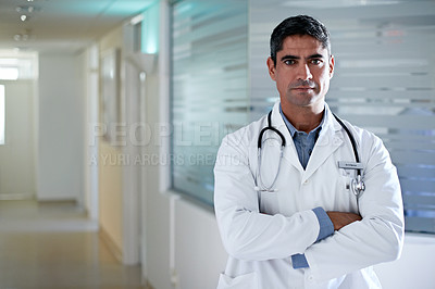 Buy stock photo Shot of a confident-looking doctor standing in a hospital corridor