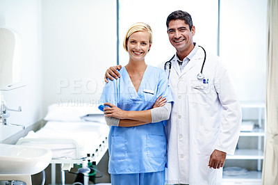 Buy stock photo Portrait of two medical professionals standing arm in arm in a hospital ward