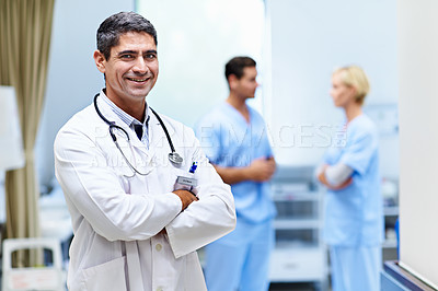 Buy stock photo Portrait of a confident doctor with medical staff in the background