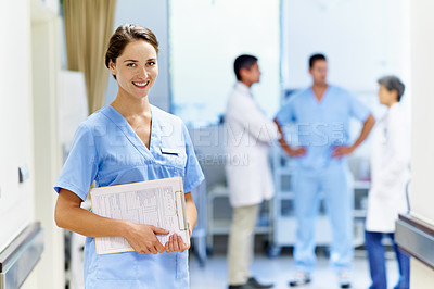 Buy stock photo Portrait of a young doctor with medical staff in the background