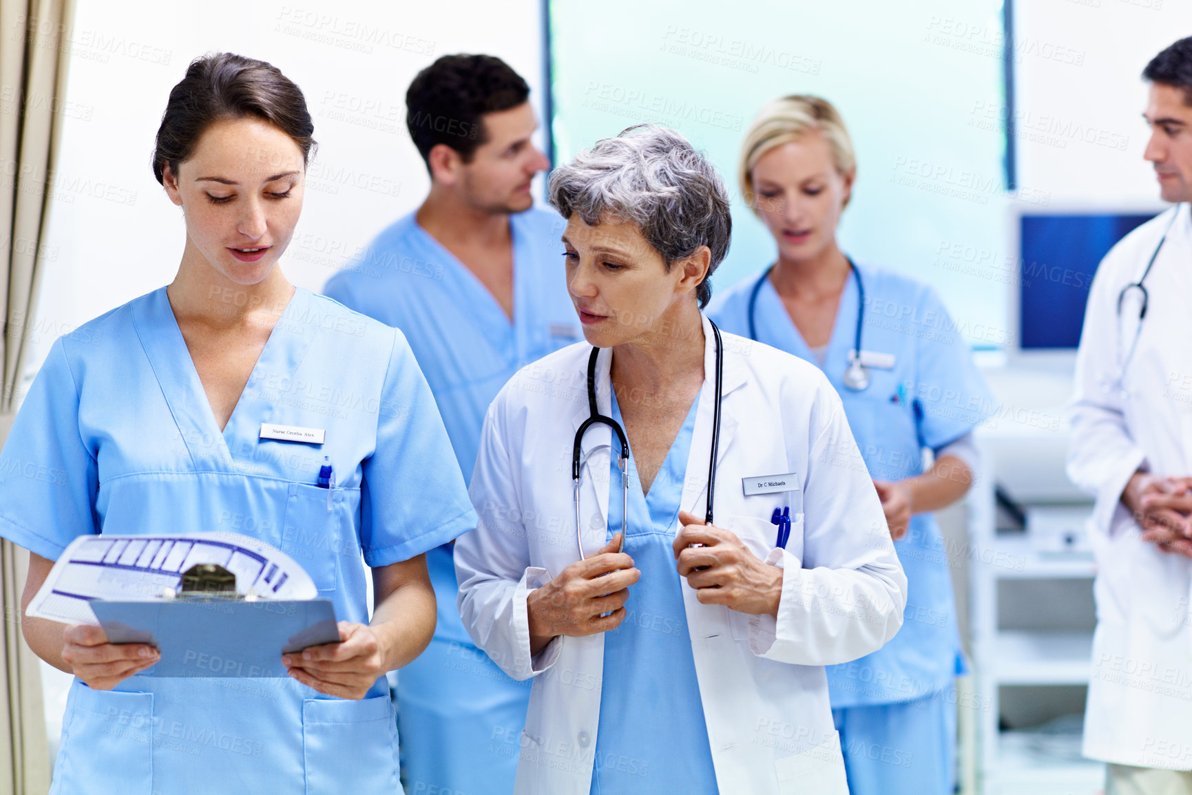 Buy stock photo Hospital, doctors and women with paperwork, reading and intern with info for treatment plan or help. Medical professional, mentor and people with clipboard, collaboration and review health report