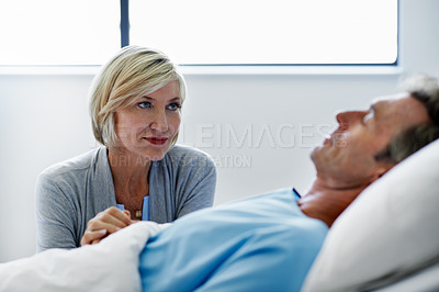 Buy stock photo Shot of a woman comforting her husband lying in a hospital bed