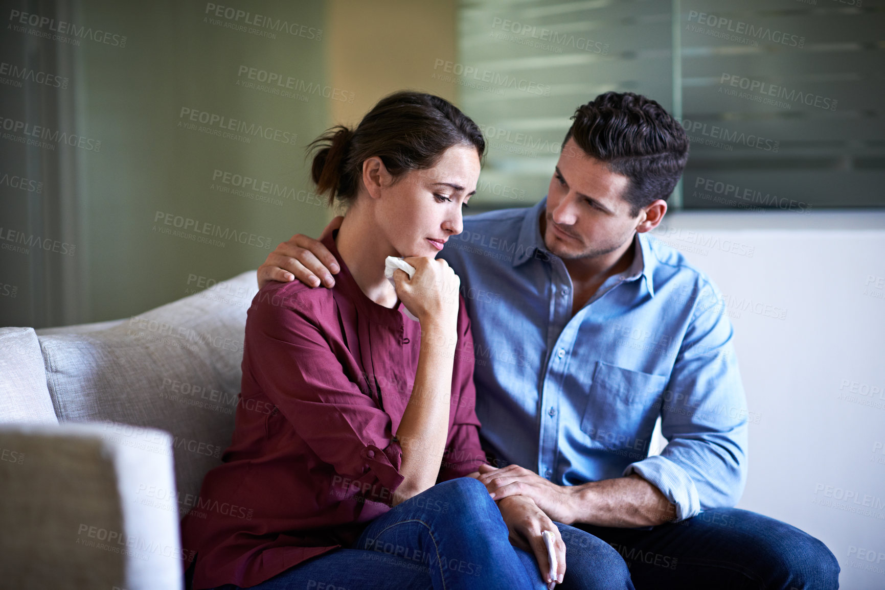 Buy stock photo Shot of a husband comforting his wife in a hospital waiting room
