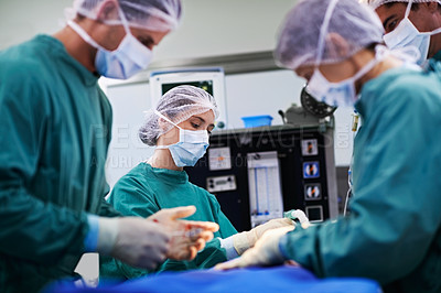 Buy stock photo Shot of a team of surgeons performing an operation