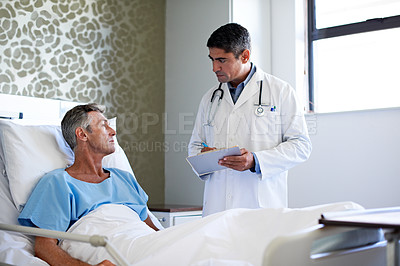 Buy stock photo Shot of a doctor having a conversation with a patient lying in a hospital bed