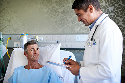 Buy stock photo Shot of a doctor having a conversation with a patient lying in a hospital bed