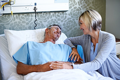 Buy stock photo Shot of a woman comforting her husband lying in a hospital bed