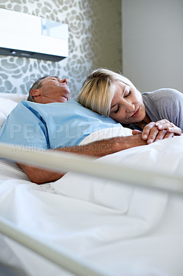 Buy stock photo Shot of a wife visiting her sleeping husband in the hospital