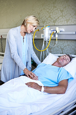 Buy stock photo Shot of a wife visiting her sleeping husband in the hospital