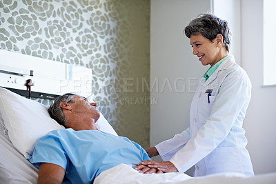 Buy stock photo Shot of a doctor talking to a patient in a hospital ward